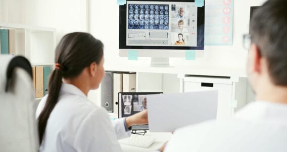 Deux professionnels de santé collaborant sur un projet numérique avec des données médicales affichées sur un écran.
