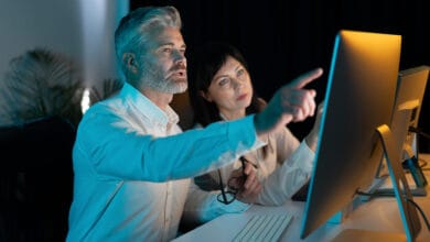 Deux professionnels collaborant devant un écran, apprenant à maîtriser l’intelligence artificielle pour transformer les processus métier.